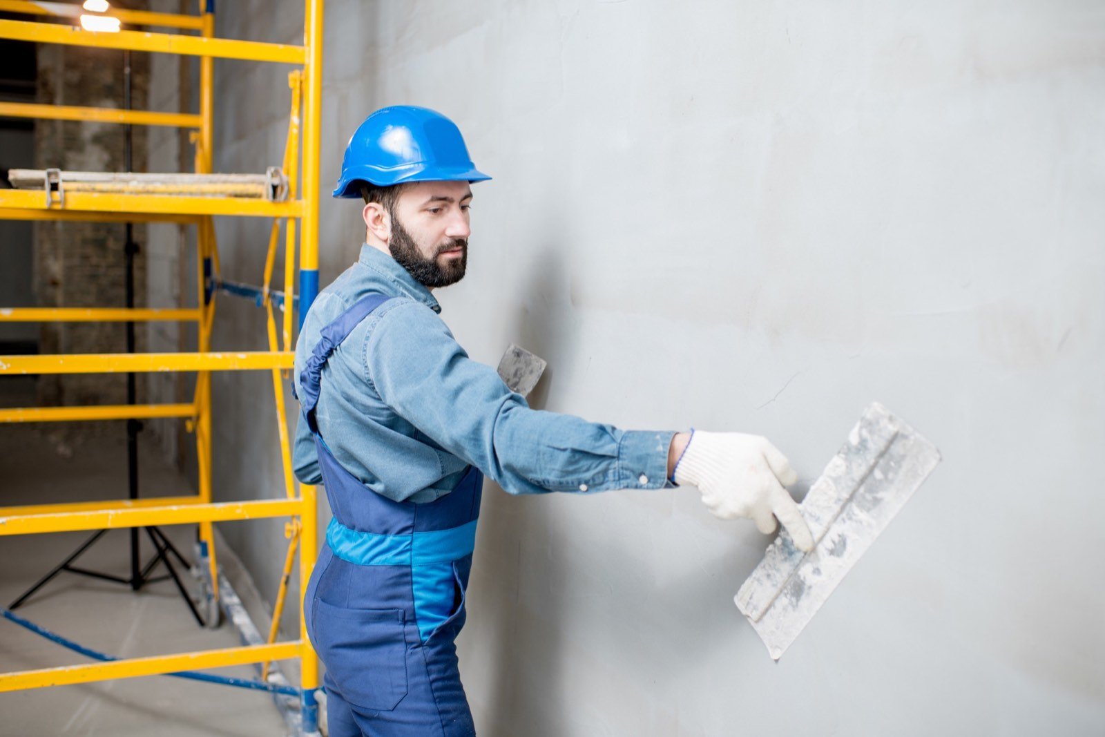 Continuous plaster spraying machine pumping gypsum plaster on wall