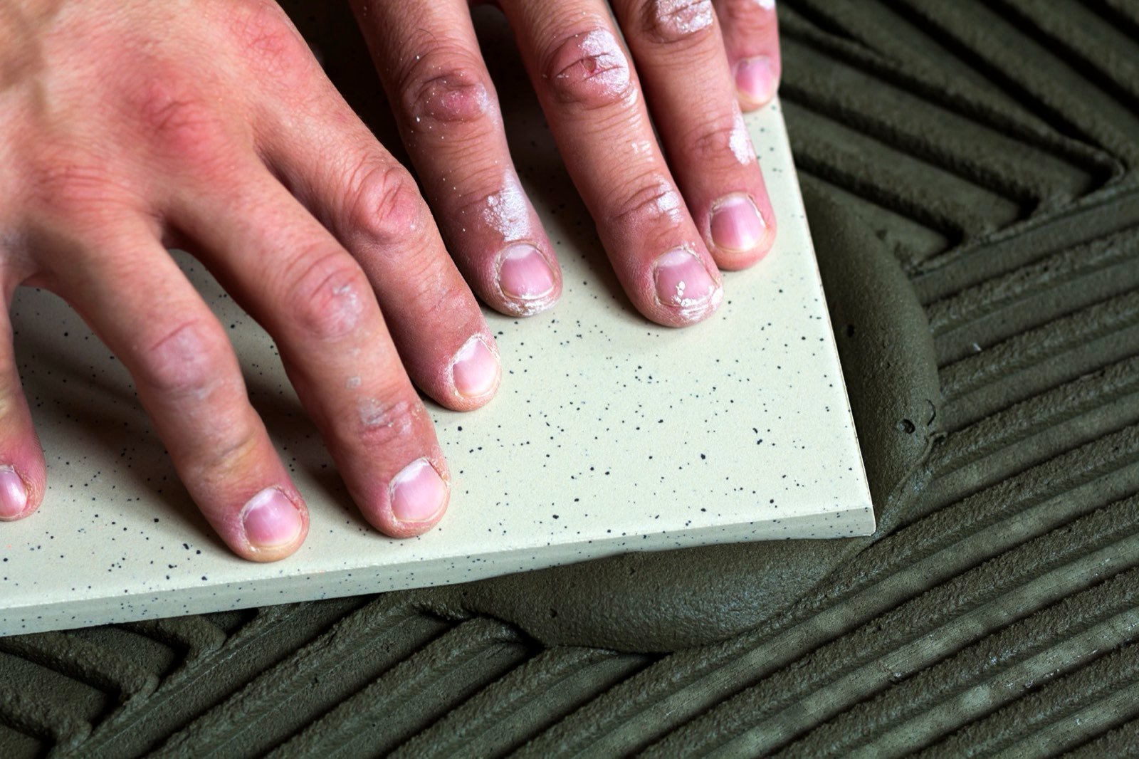 Large-format floor tiles with leveling wedges during application evaluation of adhesive open time and surface regularity