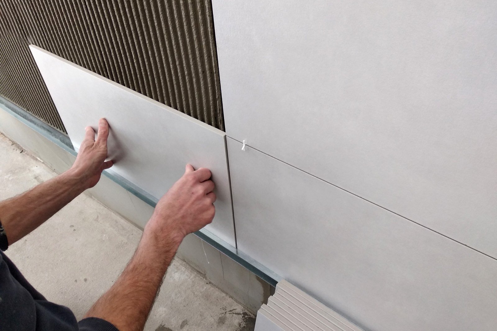 Tile adhesive application with a notched trowel